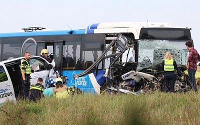 Bus and taxi collide in Friesland, injuring 14 adults & children; 4 critically hurt