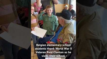 Belgian elementary school students thank World War II Veteran Reid Clanton as he visits their school