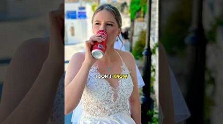 Bride walks around Greece in wedding dress whilst drinking a Coke