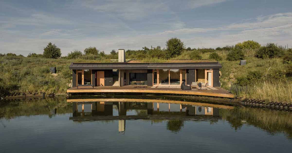 This Small Home With A Green Roof Curves Around A Pond