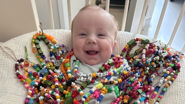 Baby with rare genetic condition is happy despite all he's endured, say his moms