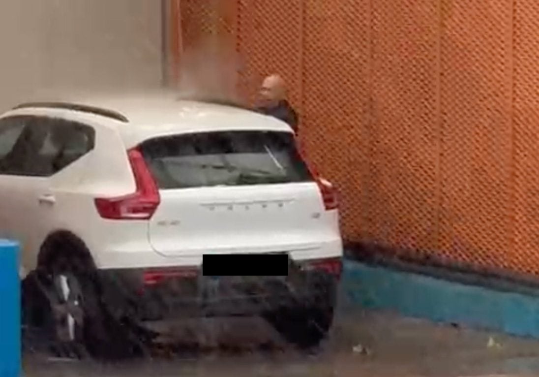 Watch: Bizarre moment man washes his car during life-threatening rain storms in southern Spain