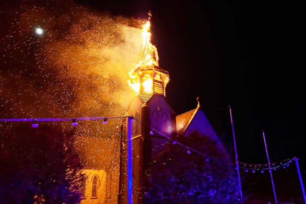 Church spire crashes to the ground in flames after lightning strike as nearby home also badly damaged